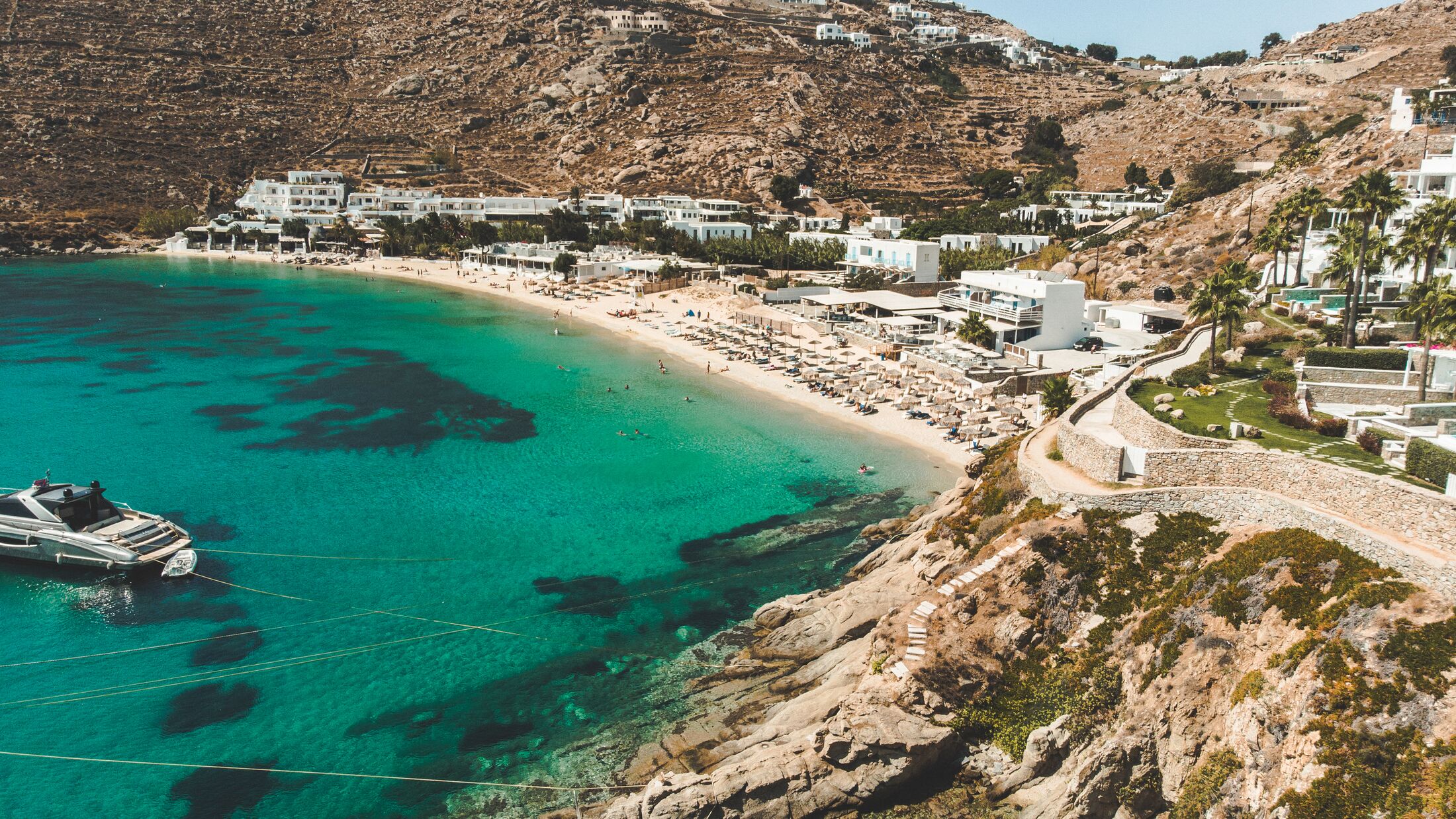 Aerial view of Psarou (Nammos) beach with luxury resorts with private pools at the island of Mykonos, Greece.