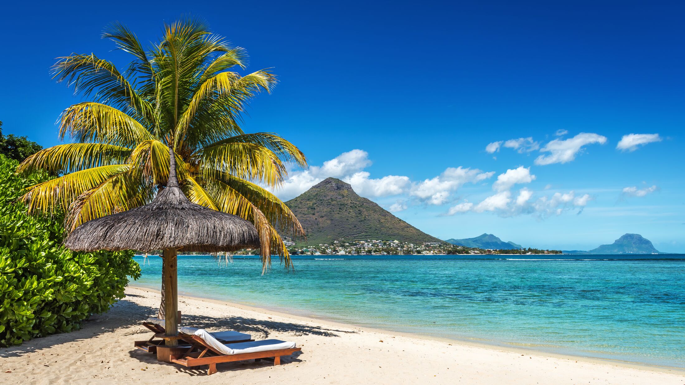 Loungers and umbrella on tropical beach in Mauritius Island, Indian Ocean