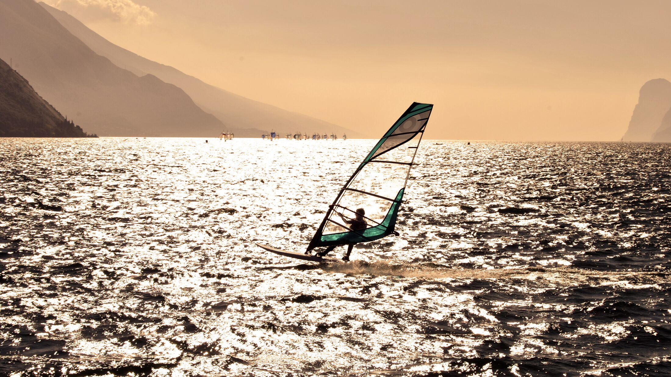 windsurfer panorama silhouette against a sparking  lake of Garda, in Trentino. Italy