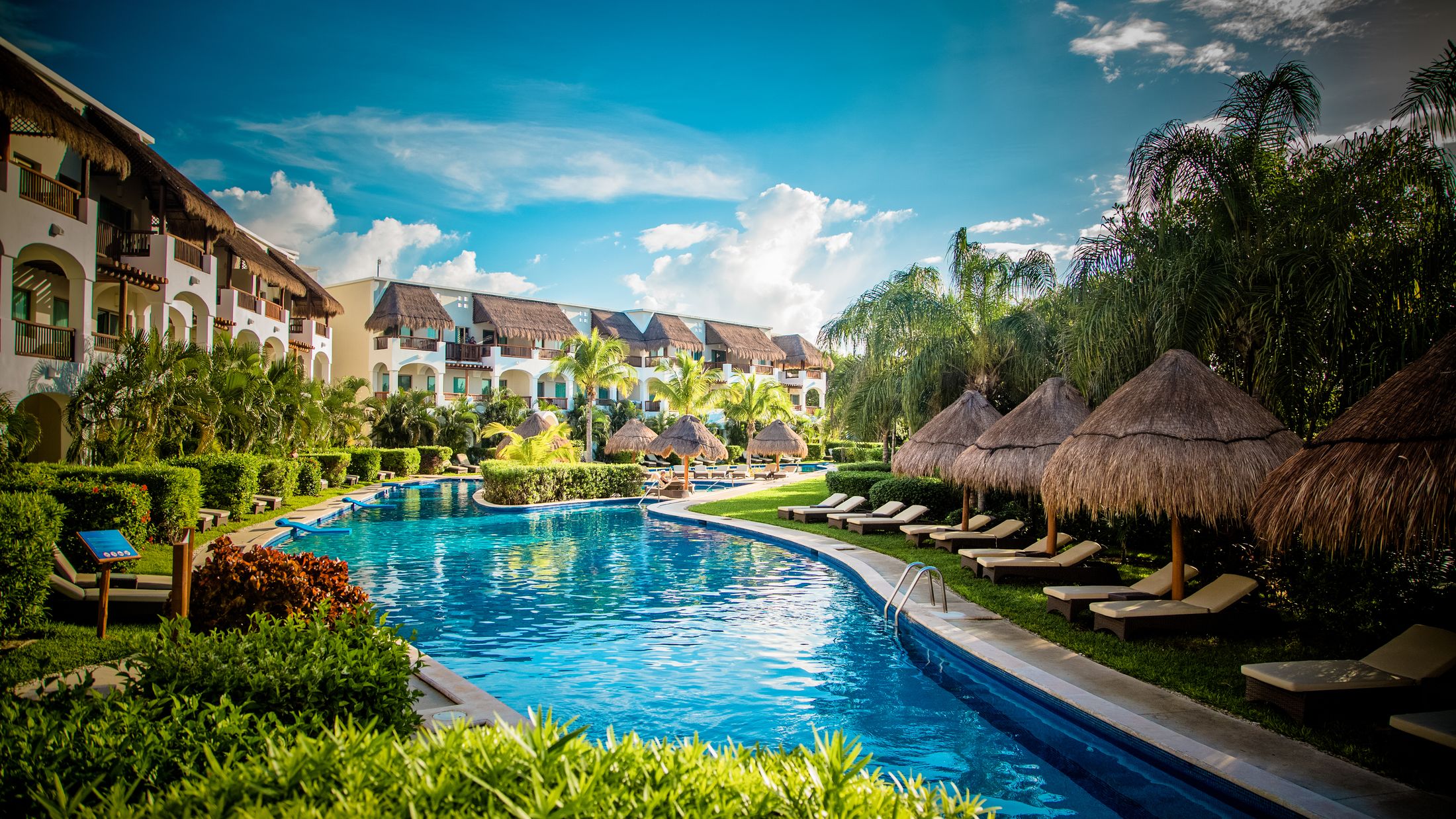 a group of lawn chairs sitting next to a pool of water